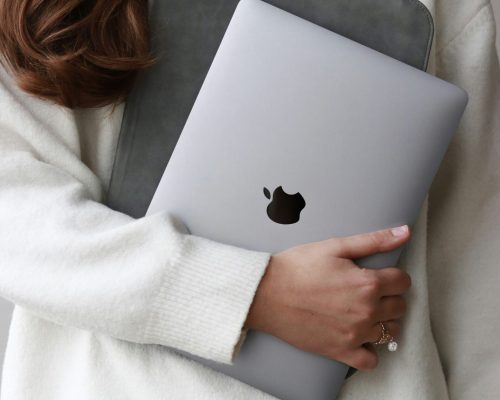 Frau hält Laptop im Arm, Symbol für selbstbestimmte Finanzentscheidungen